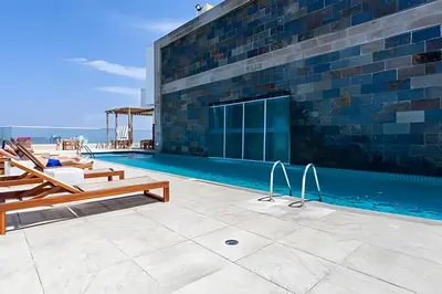 a swimming pool next to a brick building at Espectacular Apto 3 Hab Palmetto Beach 1201 in Cartagena de Indias