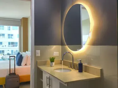 a bathroom with a sink and a mirror and a bed at Bizsar Mar 4 Piscinas Acceso privado playa BBQ privado in Cartagena de Indias