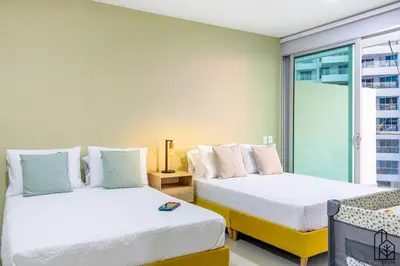 two beds in a room with a window at Bizsar Mar 4 Piscinas Acceso privado playa BBQ privado in Cartagena de Indias