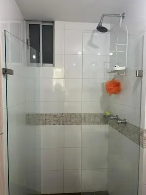 a shower with a glass door in a bathroom at Confortable Apartamento in Barranquilla