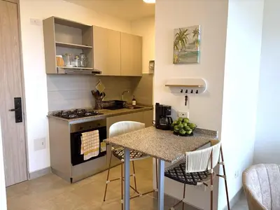 a small kitchen with a table and a stove at Apartasuite x4 Playa Piscina Jacuzzi Zona Decameron Santa Marta in Santa Marta