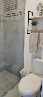a white bathroom with a toilet and a shower at Apartasuite x4 Playa Piscina Jacuzzi Zona Decameron Santa Marta in Santa Marta