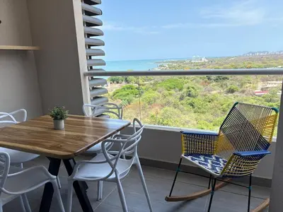 a balcony with a table and chairs and a large window at Apartasuite x4 Playa Piscina Jacuzzi Zona Decameron Santa Marta in Santa Marta