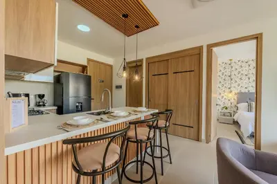 a kitchen with bar stools and a kitchen with a bed at Ubicación soñada en Cartagena | Apartamento premium en Baia Kristal in Cartagena de Indias