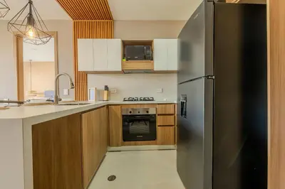 a kitchen with a stainless steel refrigerator and wooden cabinets at Ubicación soñada en Cartagena | Apartamento premium en Baia Kristal in Cartagena de Indias