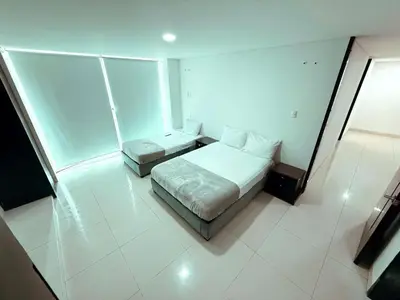 a bedroom with two beds in a white room at Apartamento a 10 min del Aeropuerto x7Pax in Cartagena de Indias
