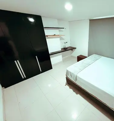 a bedroom with a bed and a black cabinet at Apartamento a 10 min del Aeropuerto x7Pax in Cartagena de Indias