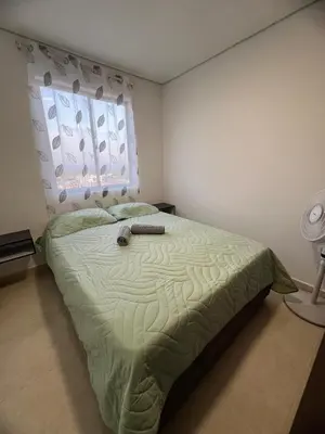 a bedroom with a green bed with a window at Apartment 5 minutes from the Airport, Sea and Center in Cartagena de Indias
