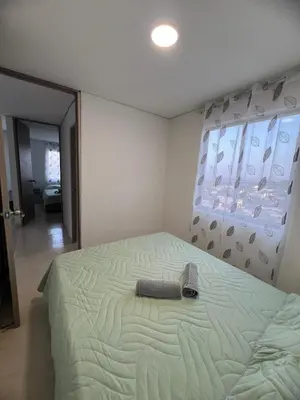 a bedroom with a bed with a book on it at Apartment 5 minutes from the Airport, Sea and Center in Cartagena de Indias
