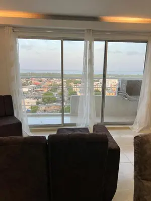 a living room with two chairs and a large window at Apartment 5 minutes from the Airport, Sea and Center in Cartagena de Indias