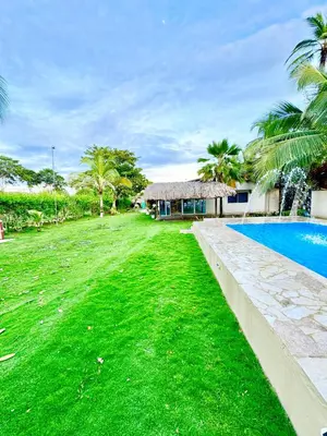 a yard with a swimming pool next to a house at Playa Virginia Beach House Privada in San Silvestre