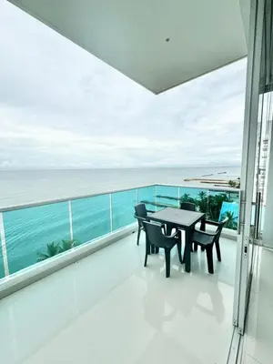 a balcony with a table and chairs and the ocean at Apartamento de lujo frente al mar in Coveñas