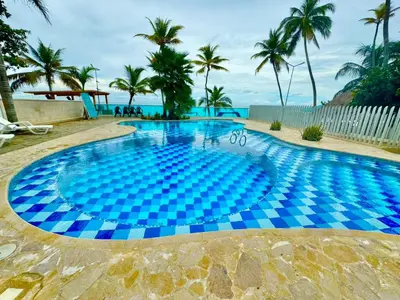 a large swimming pool with blue tiles on the beach at Apartamento de lujo frente al mar in Coveñas