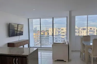 a kitchen and living room with a view of a city at Hermoso Apartamento Cartagena cerca al Mar in Cartagena de Indias