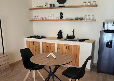 a kitchen with a table and two chairs and a refrigerator at Villa CANGGU- Villa con piscina privada, estilo mediterraneo in Tubará
