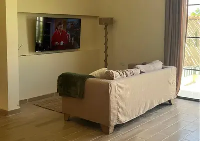 a living room with a couch and a tv at Villa CANGGU- Villa con piscina privada, estilo mediterraneo in Tubará