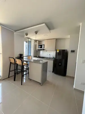 a kitchen with a table and chairs and a refrigerator at Modern Apartment in Barranquilla in Barranquilla