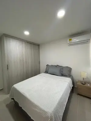 a bedroom with a large bed with a white blanket at Modern Apartment in Barranquilla in Barranquilla