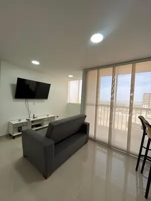 a living room with a couch and a flat screen tv at Modern Apartment in Barranquilla in Barranquilla