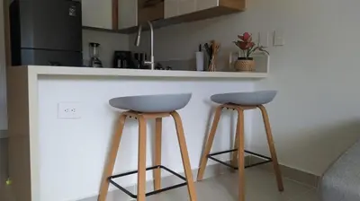 a kitchen with two bar stools at a counter at Apto de Ensueño en aguas cristalinas Baía Kristal in Cartagena de Indias