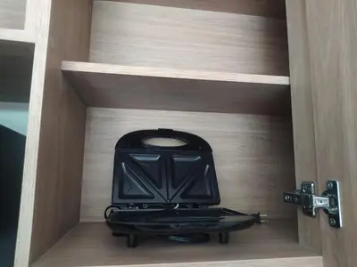 a small stove in a wooden cabinet in a room at Apto de Ensueño en aguas cristalinas Baía Kristal in Cartagena de Indias