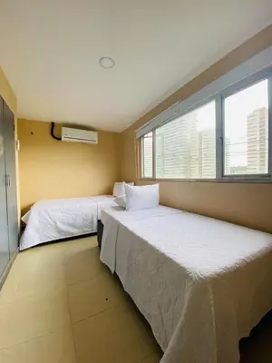 two beds in a room with two windows at Apartamento Los Lagos in Cartagena de Indias