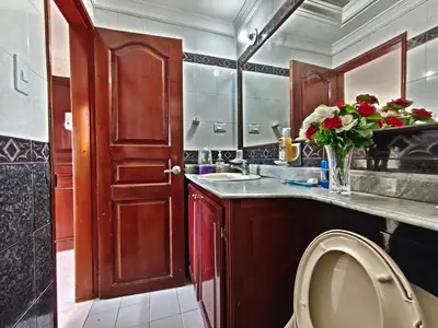 a bathroom with a sink and a vase of flowers at Comodo apartamento cerca al aeropuerto y la playa in Cartagena de Indias