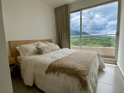 a bedroom with a bed and a large window at VISTA BAHIA Santa Marina Santa Marta in Santa Marta