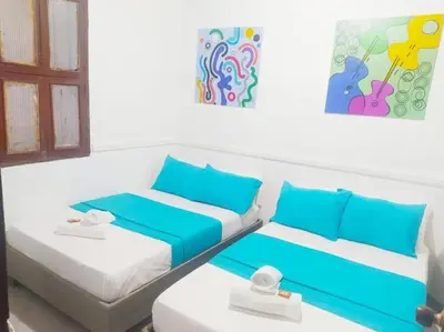 two beds in a room with blue and white at Acogedor apto en el centro historico - CER in Cartagena de Indias