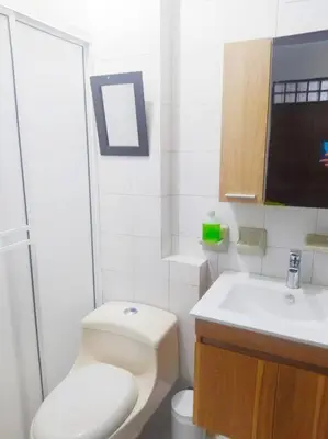 a white bathroom with a toilet and a sink at Acogedor apto en el centro historico - CER in Cartagena de Indias