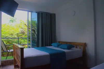 a bedroom with two beds and a large window at MANGO BREEZE Casa de Playa en Tierrabomba in Tierra Bomba