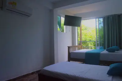 a bedroom with two beds and a window at MANGO BREEZE Casa de Playa en Tierrabomba in Tierra Bomba
