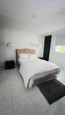 a bedroom with a large bed with white sheets and pillows at Casa a 2 minutos de la playa en playa mendoza in Tubará