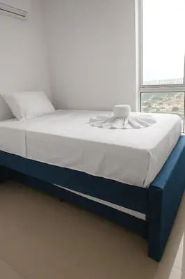a bed in a white room with a blue bed frame at Cartagena Search in the Historic Center T6 in Cartagena de Indias