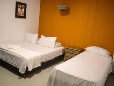 two beds in a room with white sheets at Casa gimani Betts in Cartagena de Indias