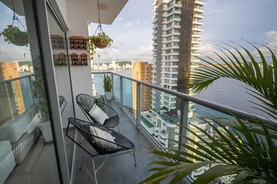 a balcony with two chairs and a view of a building at Luxury-Ocean view apartment in Bocagrande in Cartagena de Indias