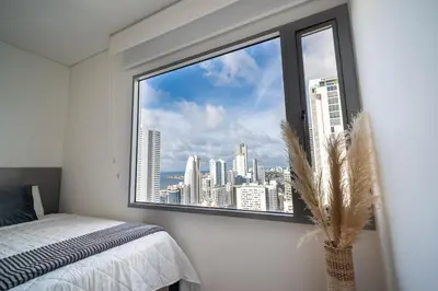 a bedroom with a window with a view of a city at Luxury-Ocean view apartment in Bocagrande in Cartagena de Indias