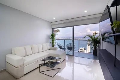 a living room with a white couch and a large window at Luxury-Ocean view apartment in Bocagrande in Cartagena de Indias