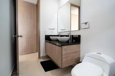 a bathroom with a sink and a toilet and a mirror at Luxury-Ocean view apartment in Bocagrande in Cartagena de Indias