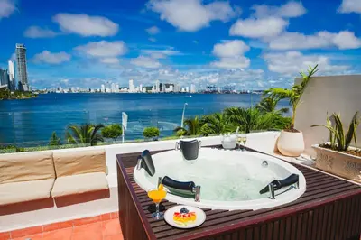 a bath tub on a balcony with a view of the water at Suite Premium con Terraza y Jacuzzi Privado in Cartagena de Indias