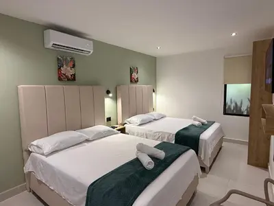 a bedroom with two beds with towels on them at Arcadia Hotel in Cartagena de Indias