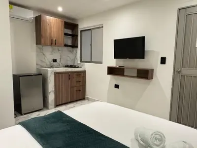a small kitchen with a bed and a television at Arcadia Hotel in Cartagena de Indias