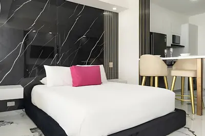 a bedroom with a white bed with a pink pillow at Escape to Paradise - Oceanfront in Cartagena in Cartagena de Indias
