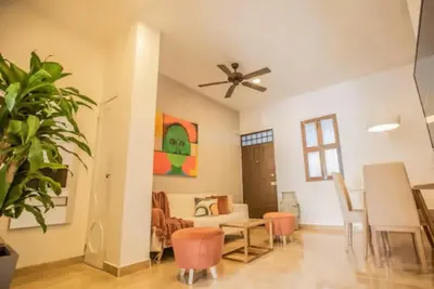 a living room with a ceiling fan and a table and chairs at Historic Getaway with Breakfast in Cartagena de Indias