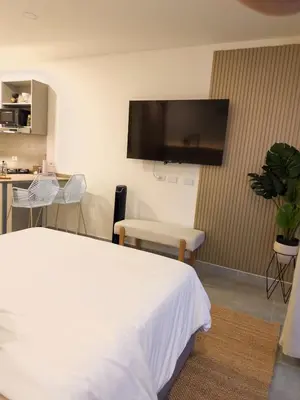 a hotel room with a bed and a flat screen tv at Aparta Suite en Santamarina - Escápate al Caribe in Santa Marta