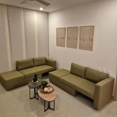 a living room with two green couches and a table at Apartamento moderno con vista al mar y piscinas 1 habitación con balcón en Manzanillo,Cartagena in Cartagena de Indias