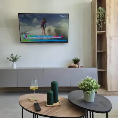 a living room with a tv on a wall at Apartamento moderno con vista al mar y piscinas 1 habitación con balcón en Manzanillo,Cartagena in Cartagena de Indias