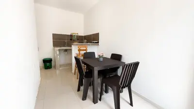 a dining room with a black table and chairs at Cabaña Datalu 1 in Coveñas