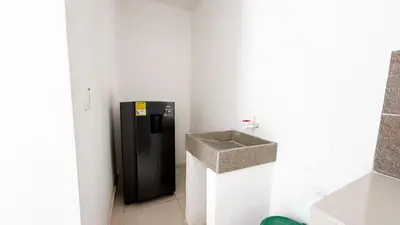 a bathroom with a black refrigerator and a sink at Cabaña Datalu 1 in Coveñas
