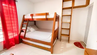a room with two bunk beds and a red curtain at Cabaña Datalu 1 in Coveñas